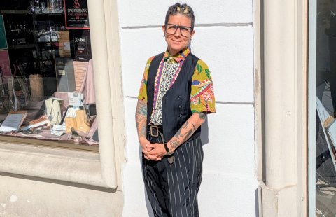 Frau steht an der Mauer gelehnt