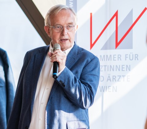 Präsident spricht mit Mikrophon zu Besuchern des Sommerfests.