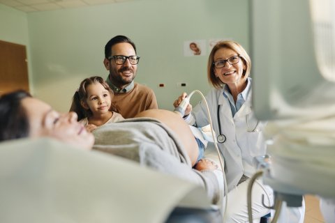 Eine Familie ist bei der Untersuchung im Rahmen des Eltern-Kind-Passes.