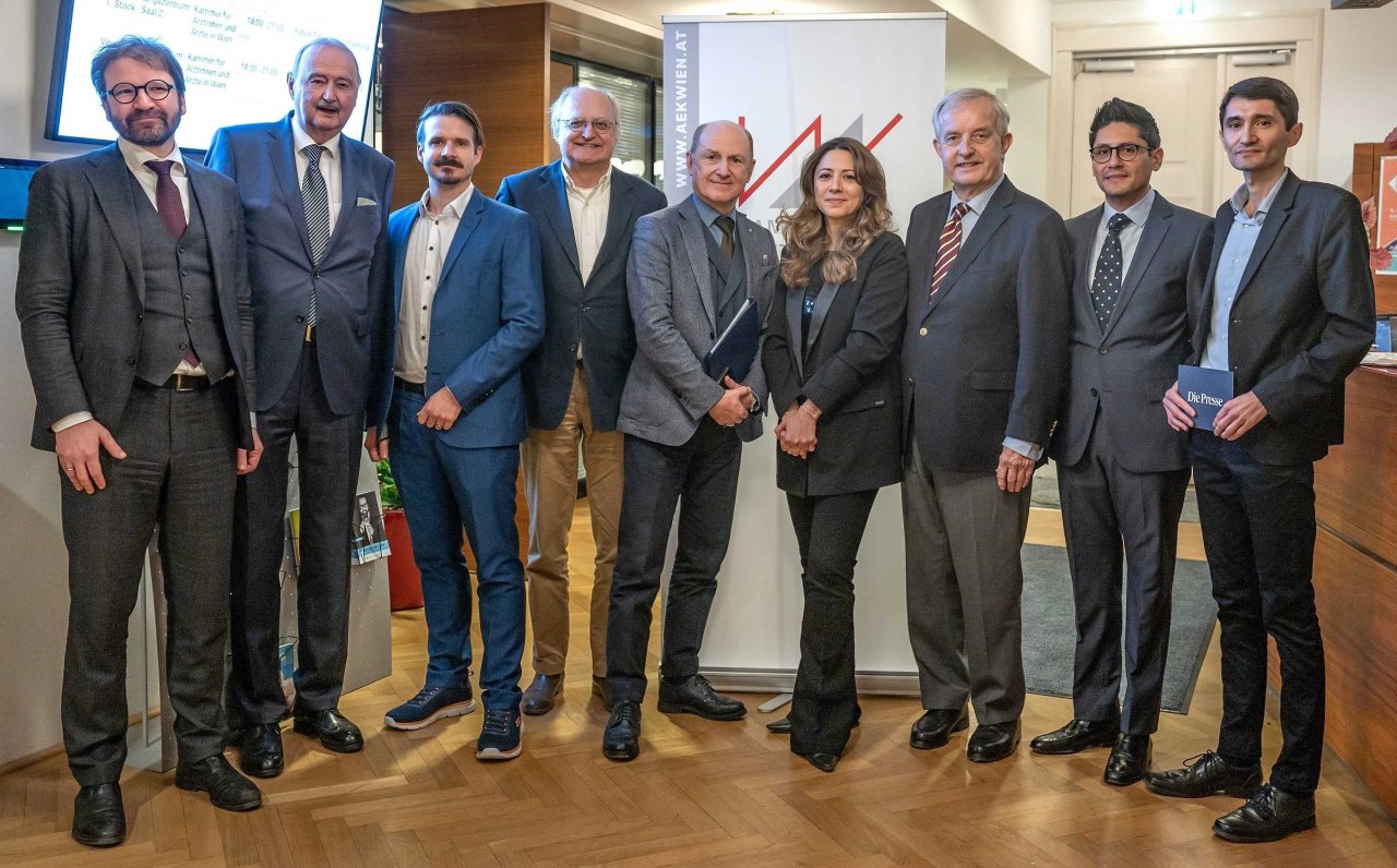 Neun Personen stehen zu einem Gruppenfoto beieinander.