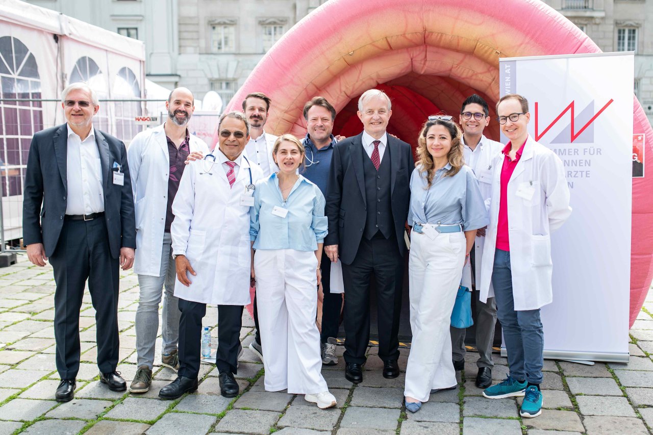 Ein Foto vom Ärztekammer-Team beim Aktionstag Gesundheit vor dem Eingang - auf dem Foto sind zu sehen - von links nach rechts zehn Personen: Johannes Kastner, Ernest Zulus, Hamid Schirasi-Fard, Benjamin Glaser, Katayoun Tonninger-Bahadori, Paul Schönfeld, Präsident Johannes Steinhart, Vizepräsidentin Naghme Kamaleyan-Schmied, Vizepräsident Eduardo Maldonado-González und Philipp Ubl.