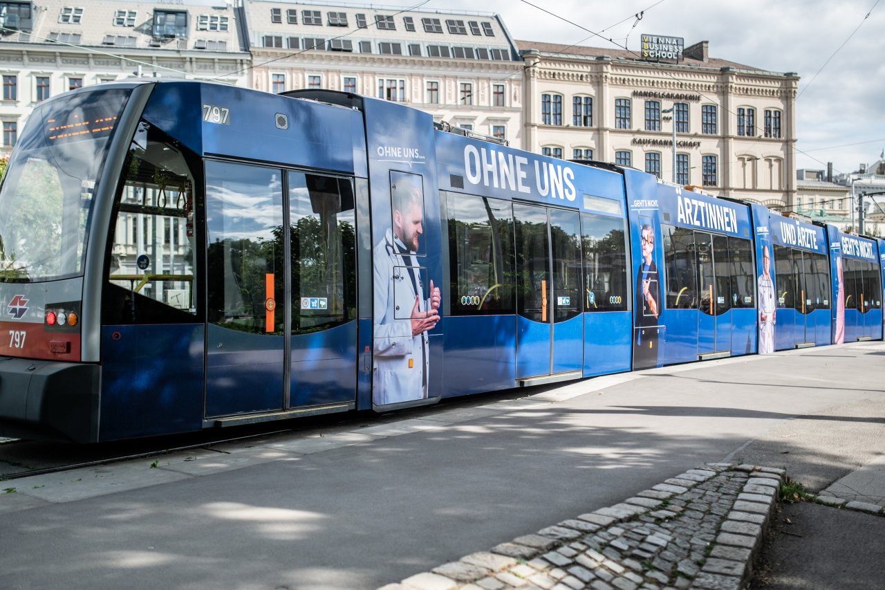 Ein Straßenbahngarnitur mit der aufgeklebten Kampagne der Ärztekammer.