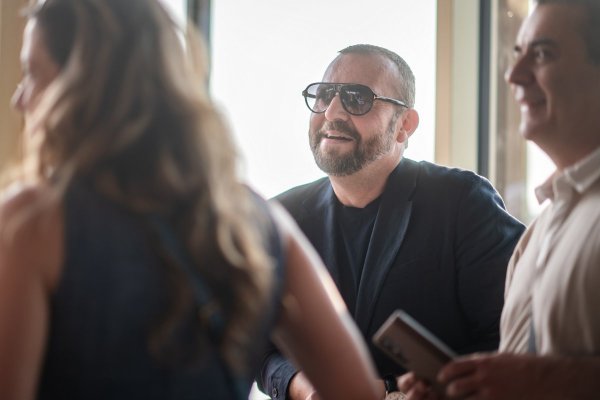 Gruppe von drei Personen, im Zentrum ein bärtiger Mann mit Sonnenbrille.