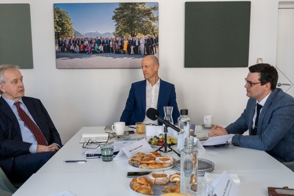 Drei Männer an einem Tisch sitzend.