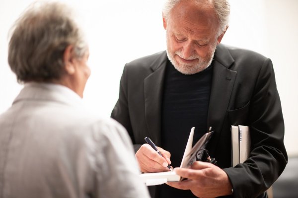 Mann der ein Buch signiert