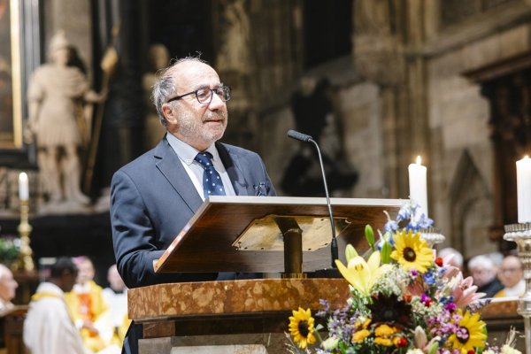 Ein Mann steht am Pult in der Kirche und spricht.