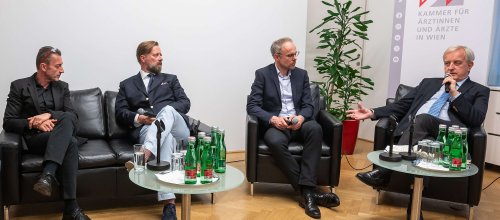 Beim KI-Symposium sitzen, von links nach rechts, die Herren Andreas Klein, Bart de Witte, Christoph Bock und Johannes Steinhart beisammen und diskutieren.