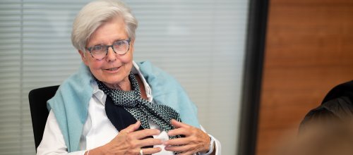 Frau mit Kurzhaarfrisur und Brille.