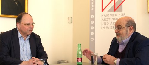 Zwei Männer sitzen zusammen an einem Tisch