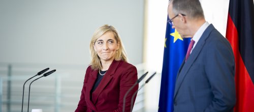 Gesundheitsministerin Nina Warken und Bundeskanzler Friedrich Merz hinter Pulten mit Mikrofonen.