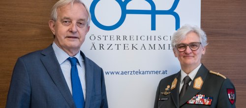Zwei Personen, ein Mann und eine Frau, stehen nebeneinander und blicken direkt in die Kamera.
