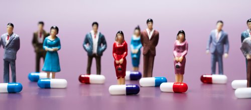 Weibliche und männliche Zinnfiguren stehen vor Pillen 