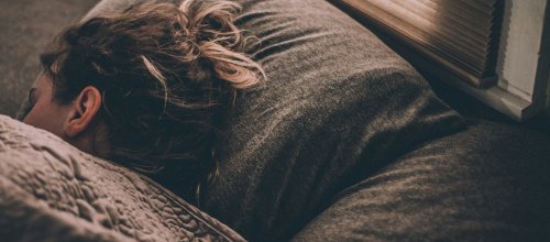 Frau liegt schlafend in einem Bett