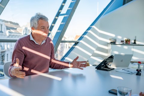 Mann sitzt vor Fenster und gestikuliert in Gesprächssituation