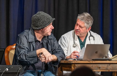 Zwei Männer, davon einer Arzt, sitzen an einem Tisch im Gespräch