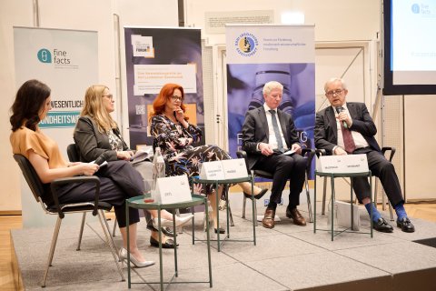 drei Frauen und zwei Männer am Podium