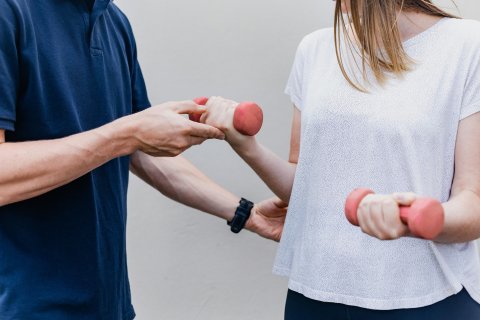 Reha-Szene mit Hanteln - Patientin mit Therapeut