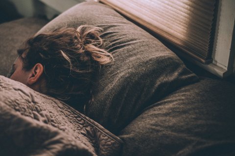 Frau liegt schlafend in einem Bett