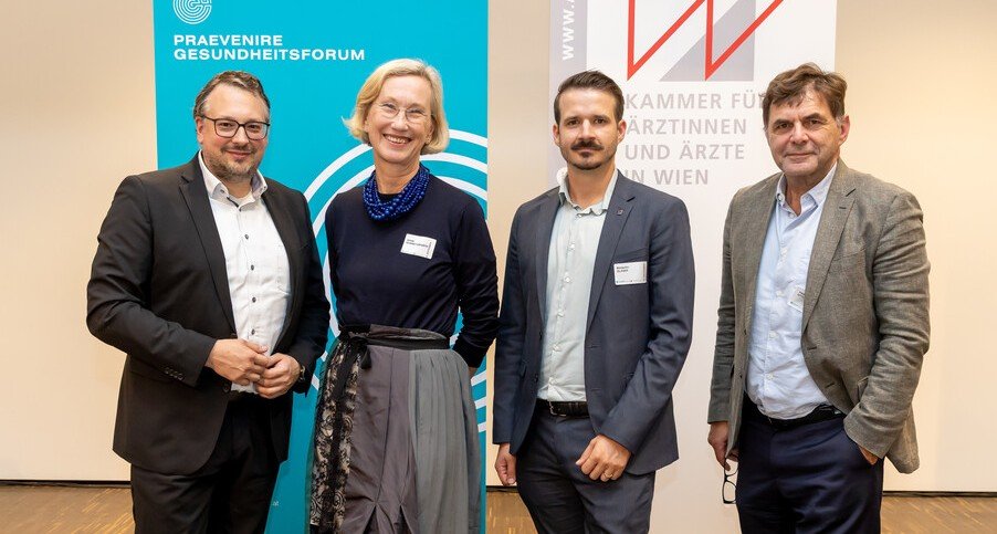 Drei Männer und eine Frau stehen