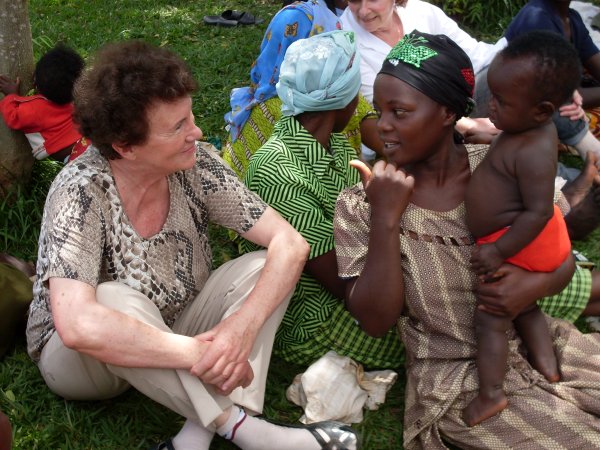 Frau Hengstberger sitzt auf einer Wiese am Boden mit einer anderen Frau, die ein Baby bei sich hat