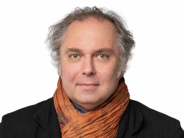 Der Mediziner Kurt Stastka im Porträt mit dunklem Mantel oder Sakko und einem braunen Schal.