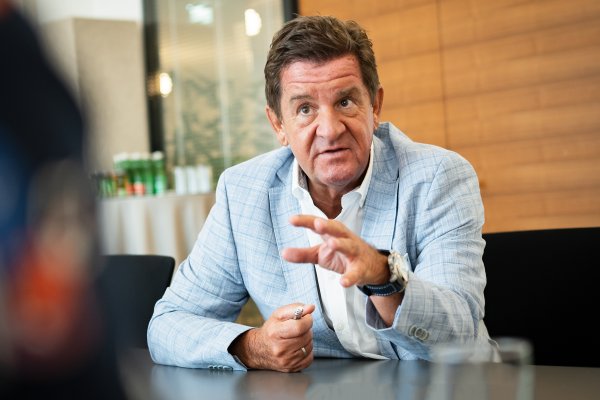 Mann in kariertem Sakko gestikuliert 