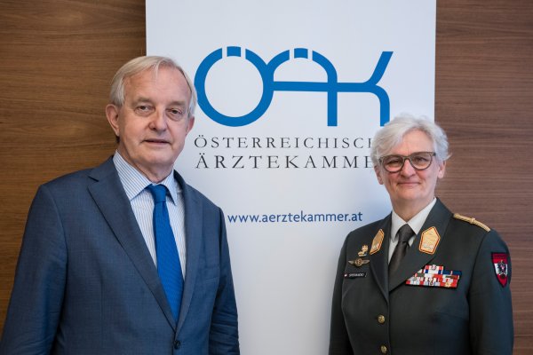 Zwei Personen, ein Mann und eine Frau, stehen nebeneinander und blicken direkt in die Kamera.