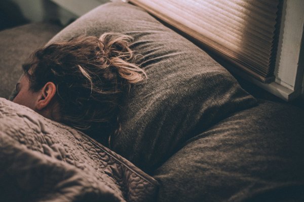 Frau liegt schlafend in einem Bett